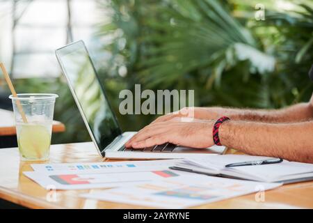 Hands of freelance UI designer sitting at cafe table and working on website interface Stock Photo
