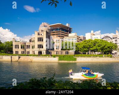 The Hiroshima Peace Memorial (Genbaku Dome, Atomic Bomb Dome or A-Bomb Dome). Also a Gangi Water Taxi on the Ota River in Hiroshima, Japan. Stock Photo