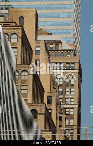 New York High Rise facades, close up detail of set back steps and geometric designs, old and new contrasted, a tall no-setback modern building last. Stock Photo