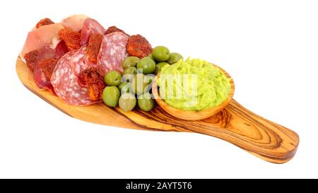 Gran antipasto snack selection on an olive wood serving board with salami, cured meat slices and a bowl of crushed avocado dip isolated on a white bac Stock Photo