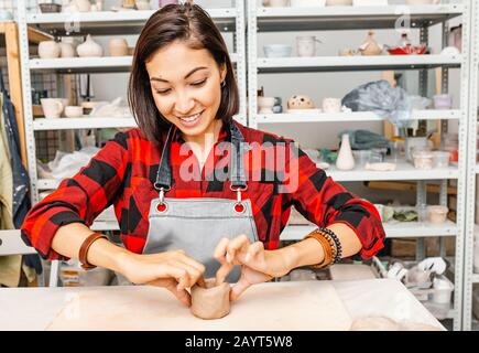 Young woman friends create clay and ceramic art dishes in pottery workshop Stock Photo