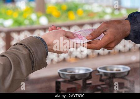 Woman Hand holds Turkish Lira 10 paper Money to pay for Street Food in Istanbul Stock Photo