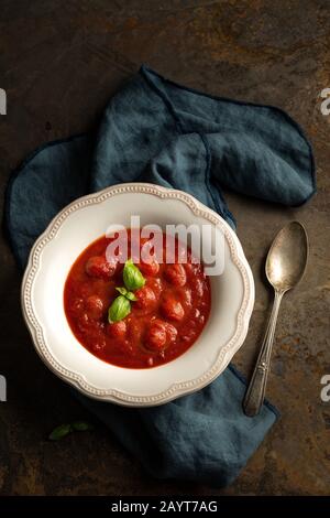 Tomato soup with basil served in the white bowl. Stock Photo