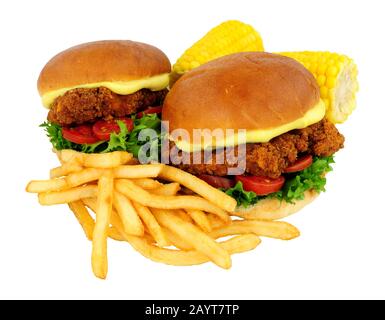 Southern fried chicken sandwiches with French fries and mayonnaise in brioche bread rolls isolated on a white background Stock Photo