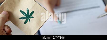 Male arm holding paper packet Stock Photo