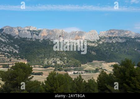 View of the Dentelles de Montmirail Mountains from the winery Domaine de Coyeux in the Vaucluse department of the Provence-Alpes-Côte d'Azur region in Stock Photo