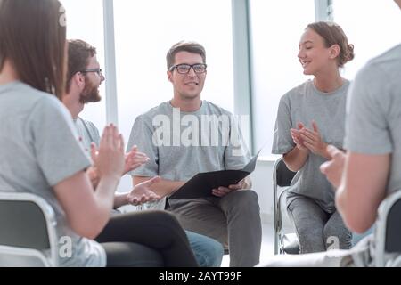 team of young people greeted the speaker with applause Stock Photo