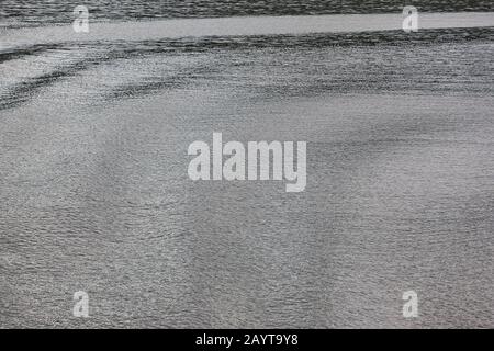 Soft waves on the sea. Water surface background. Reflection Stock Photo