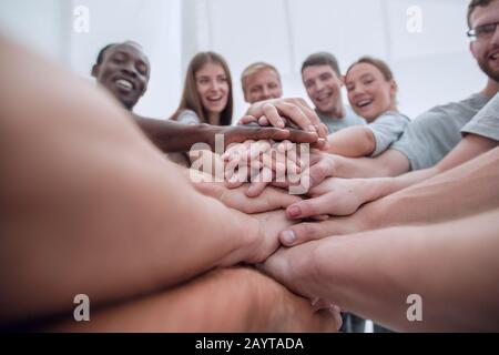 close up. international group of young people putting their hands together Stock Photo