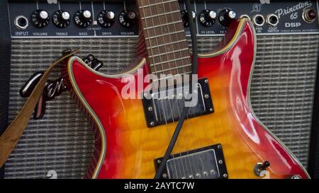 Hohner electric guitar leaning against a Fender DSP Princeton 65 amplifier. Stock Photo