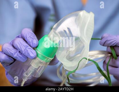 Nurse prepares oxygen mask in a hospital, conceptual image Stock Photo