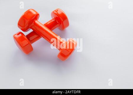 Couple of orange dumbbells on white background, copy space Stock Photo