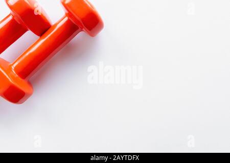 Couple of orange dumbbells on white background, copy space Stock Photo