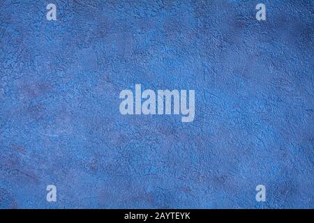 Blue spotted scratched stucco background closeup, rough cement texture backdrop, concrete grunge textured wall, dark blue decorative art plaster board Stock Photo