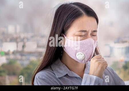PM2.5. people feeling sick from air pollution, environment has harmful or poisonous effects. woman in the city wearing face mask to protect herself be Stock Photo