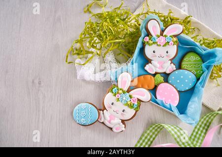 Beautiful present box full of sweet gingerbread in form of egg, bunny and carrot for spring holiday. Decorated cookies with colorful glaze for happy easter Stock Photo
