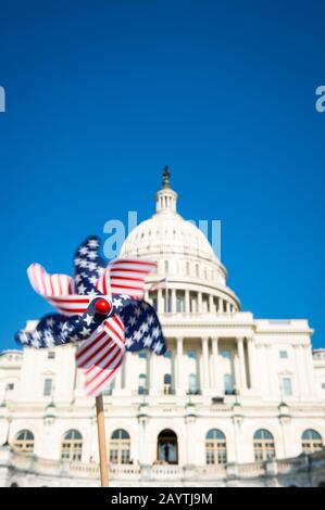 Motion blur view of American flag pinwheel spinning in sunny blue sky in front of the US Capitol building in Washington DC, USA Stock Photo