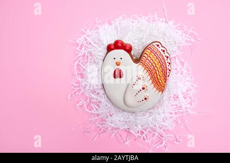 Top view of trendy colored background with homemade gingerbread in shape of chicken. Easter biscuit painted with colorful glaze. Concept of tradition and preparation. Stock Photo