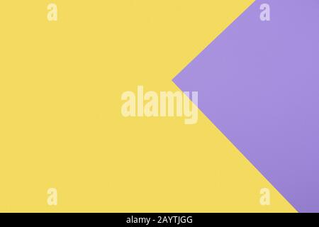 Combination of yellow and purple paper sheets overlaid in triangle shape. Abstract geometric background, copy space. Stock Photo