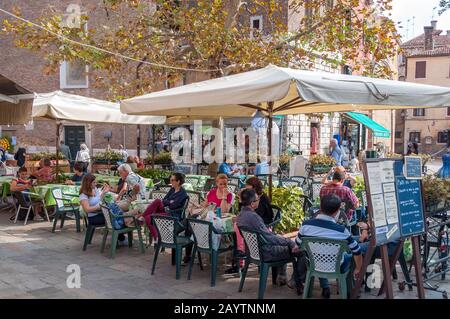 Venice, Italy - September 27, 2013: People dining and relaxing at outdoor restaurant in Venice Stock Photo