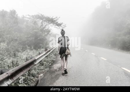 Man walking on the road in fog Stock Photo