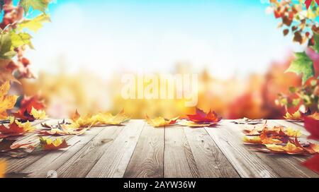 Autumn maple leaves on wooden table front. Falling leaves natural light warm background. 3d rendering Stock Photo