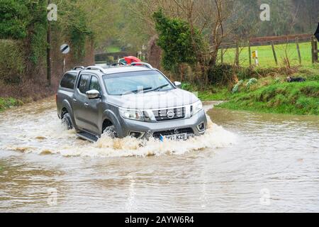 Car driving through a flooded ford in Much Hadham, Hertfordshire. UK Stock Photo