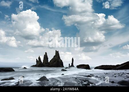 Gorgeous landscape with basalt rock formations Troll Toes on Black beach, stormy ocean waves and cloudscape. Reynisdrangar, Vik, Iceland Stock Photo