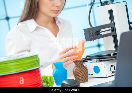 Young female designer works with a 3D printer in a design studio Stock Photo