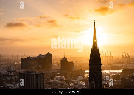 The sun shines through the church tower of St. Nikolai church in the city centre of Hamburg, Hamburg, Germany Stock Photo