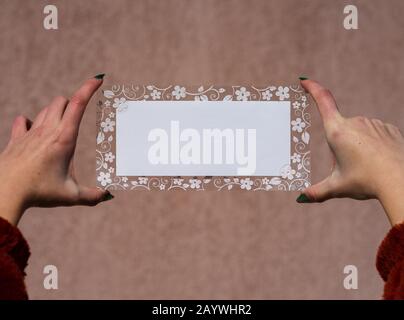 Empty space for text with decorated floral frame, greeting card design poster banner or ivitation . hand holding a blank sheet of paper. Rectangular t Stock Photo