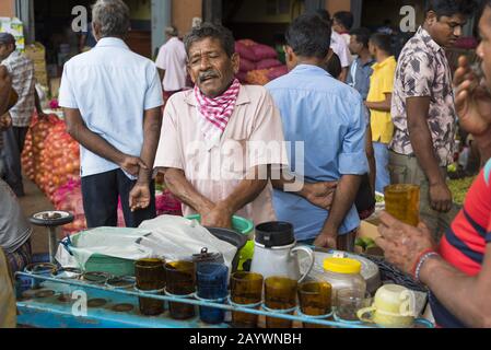 Dambulla, Sri Lanka: 18/03/2019: Inside fruit and vegetable whoelsale market. Men selling refreshments, tea, coffee.