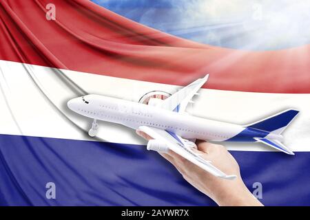 Airplane in hand with national flag of Paraguay on a background of blue sky with sunbeams Stock Photo