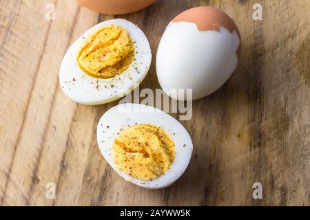Boiled chicken eggs on wooden board with pepper flakes Stock Photo
