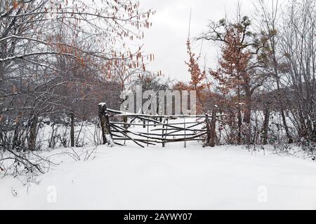 Fence of wooden rods in a snowy garden Stock Photo