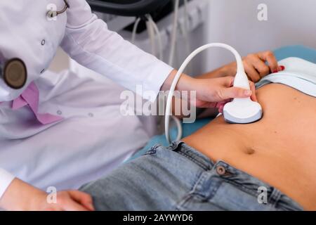 Ultrasound sensor of modern ultrasonic scanner in young woman doctor's hands preparing for a device scan. Helthcare concept. Stock Photo