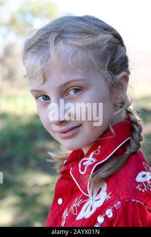 Portrait of a girl with blonde french braids wearing an elaborate cowboy shirt Stock Photo