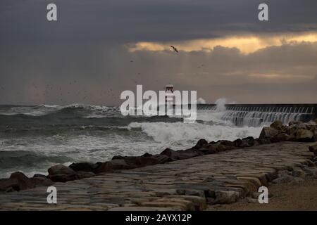 Dramatic stormy winter sunset at the Douro river mouth north pier and beacon. Stock Photo