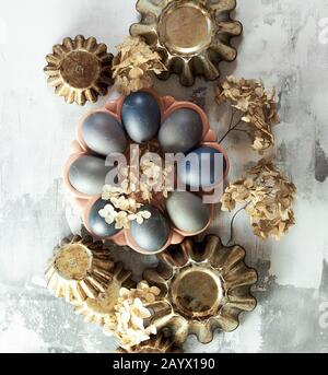 Easter composition from blue eggs, cake forms, dry flowers on concrete background, copy space, Christian religious festival concept and design Stock Photo