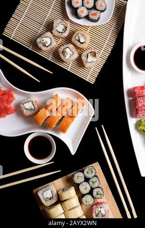 Sushi with chopsticks. Sushi roll japanese food in restaurant. California Sushi roll set with salmon, vegetables. Vertical image Stock Photo