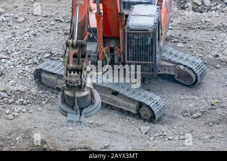 Magnetic crane loading scrap metals on the ruins of a construction site Stock Photo