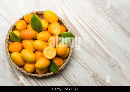 Pile of kumquat fruits, chinese tangerines, on wooden table. Stock Photo