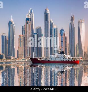 Panorama of Dubai with ship against skyscrapers in UAE Stock Photo