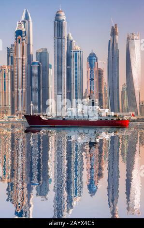 Panorama of Dubai with ship against skyscrapers in UAE Stock Photo