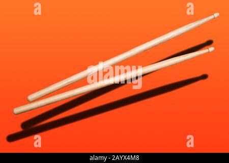 two wooden drumsticks on red background Stock Photo