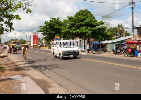 Street scene with a minibus, motorcycle taxis and people in Iquitos, Peru. Stock Photo