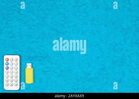 A flash drive and a small control panel are on a colored background. Stock Photo