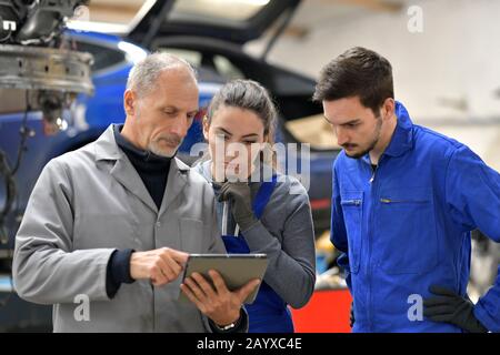 Apprentice with instructor using tablet in workshop Stock Photo