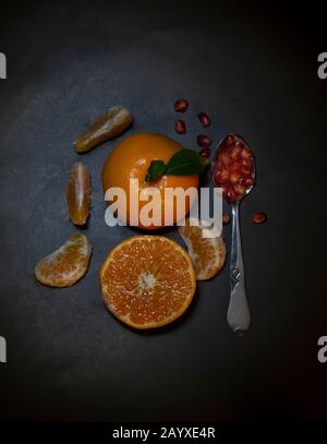 Close up photo of orange and slices on black background Stock Photo