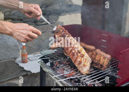 Hands turning pork chops on the grill. Concept of food. Copy space. Stock Photo